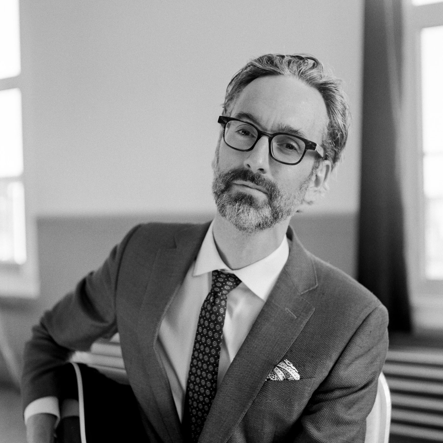 Black and white image of Canadian folk-jazz musician David Myles leaning back onto his chair armrest